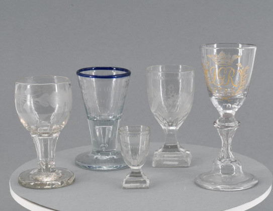 Ein Pokal mit Monogramm und ein Schnapsglas mit blauem Rand