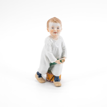 PORCELAIN FIGURINE OF A BOY WITH STICK AND DRUM