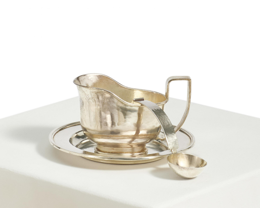 Sauciere mit Löffel auf rundem Untersatz